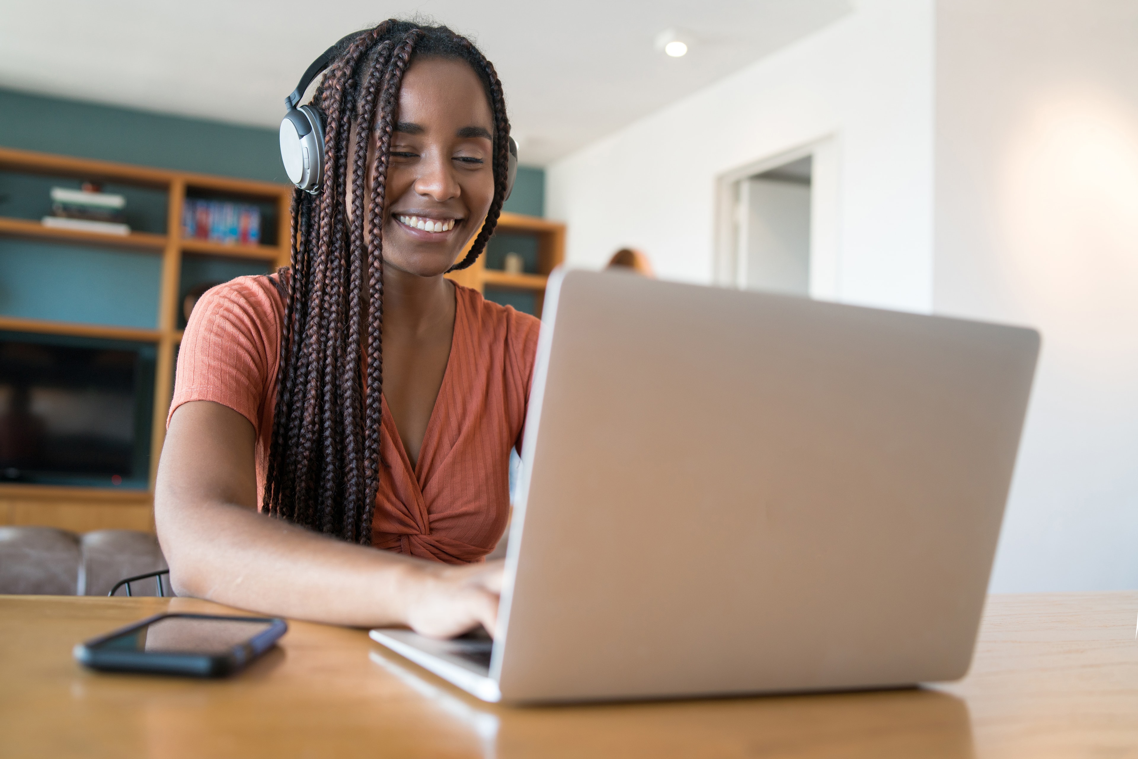 Professional woman with curly hair in yellow blazer working confidently on laptop, representing modern learning and education technology